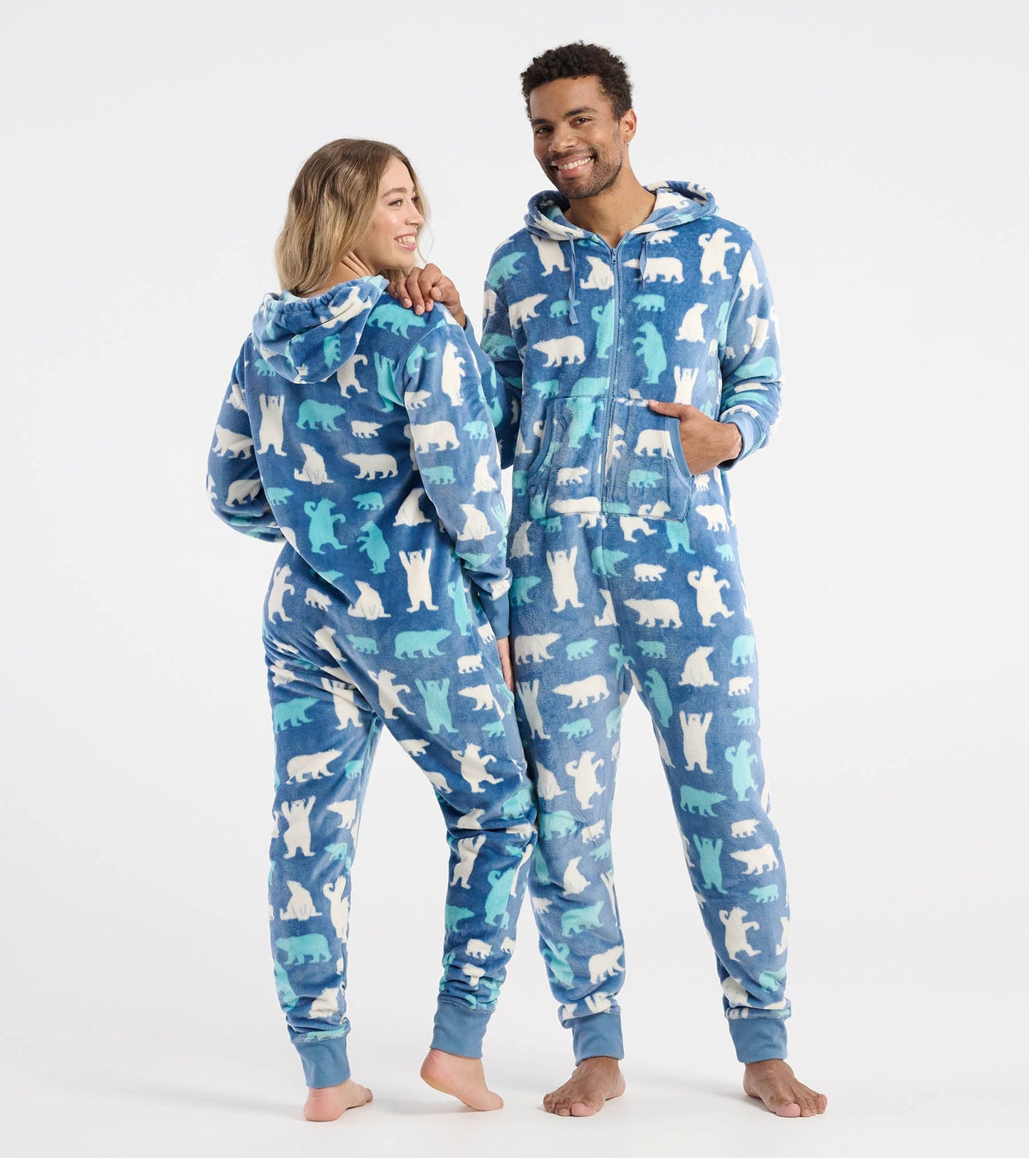 Blue fleece jumpsuit featuring a polar bear pattern, with a hood and front zipper, worn by two models.