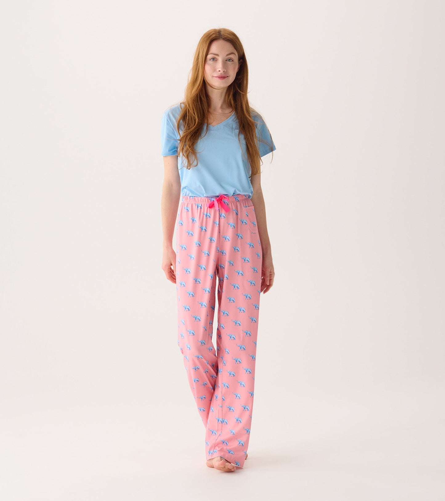 Pink pajama pants with blue elephant print and a drawstring waist, paired with a light blue top.