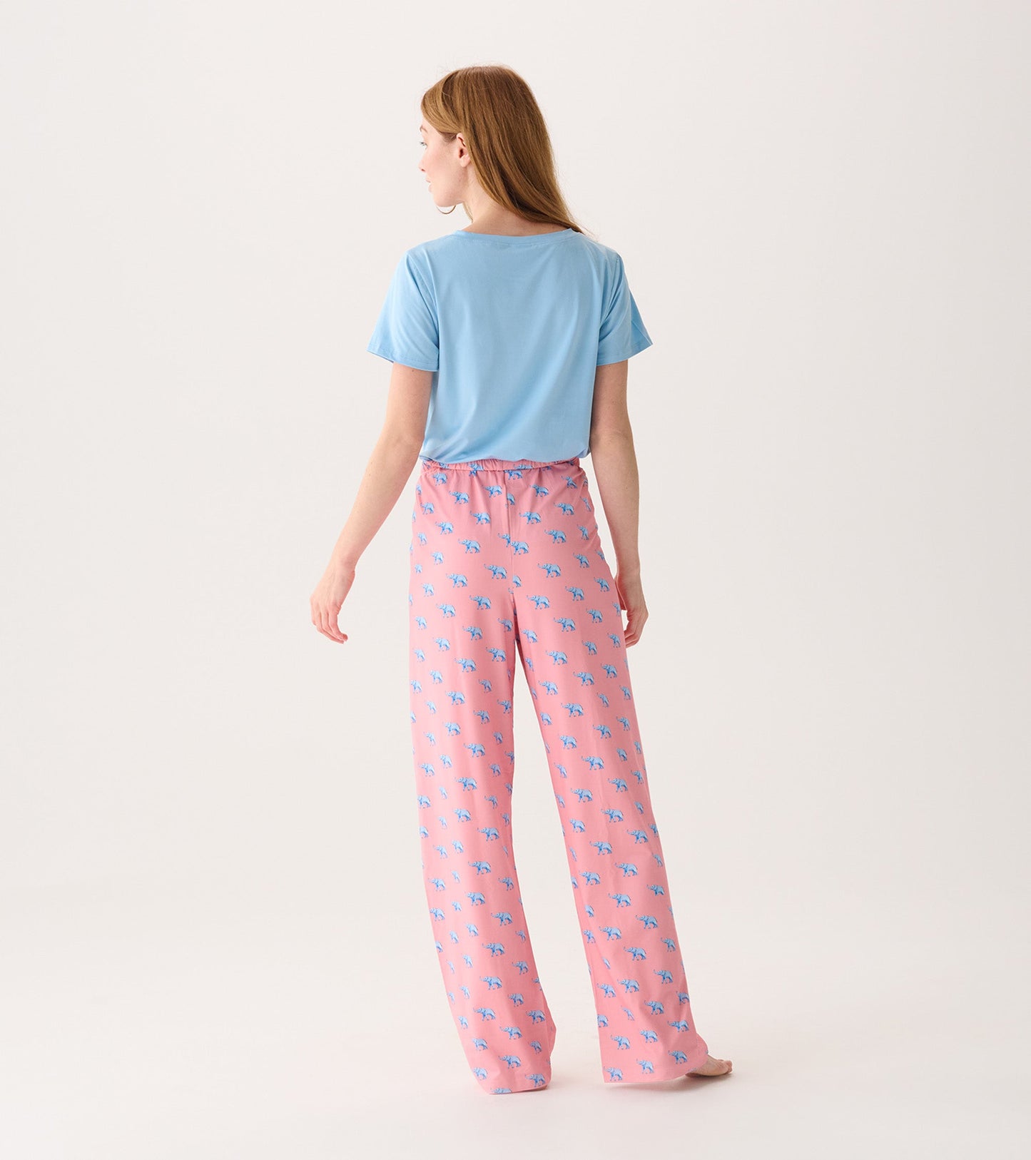 Pink pajama pants with a playful blue elephant pattern, featuring a relaxed fit and elastic waistband.