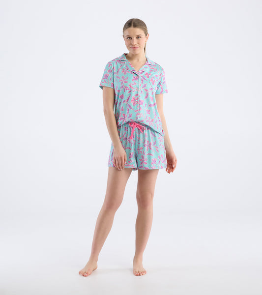 Turquoise short pajama set featuring pink batik flower patterns, with a short-sleeve top and elastic waistband shorts.