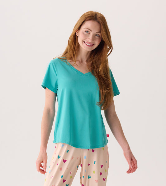 Teal V-neck t-shirt with short sleeves, paired with patterned pajama pants featuring colorful hearts.