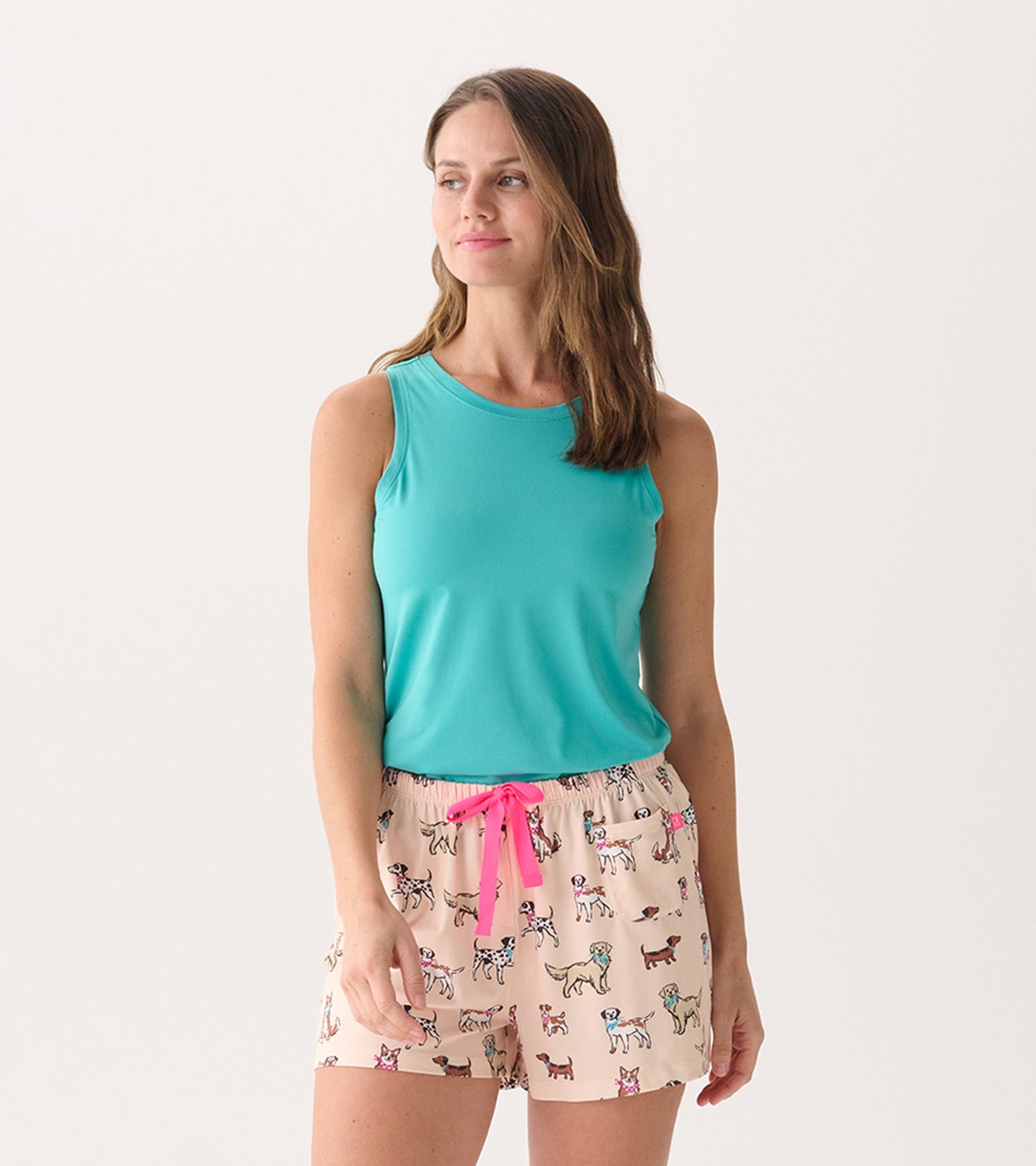 Turquoise scoop neck tank top worn with patterned shorts featuring playful dog designs.