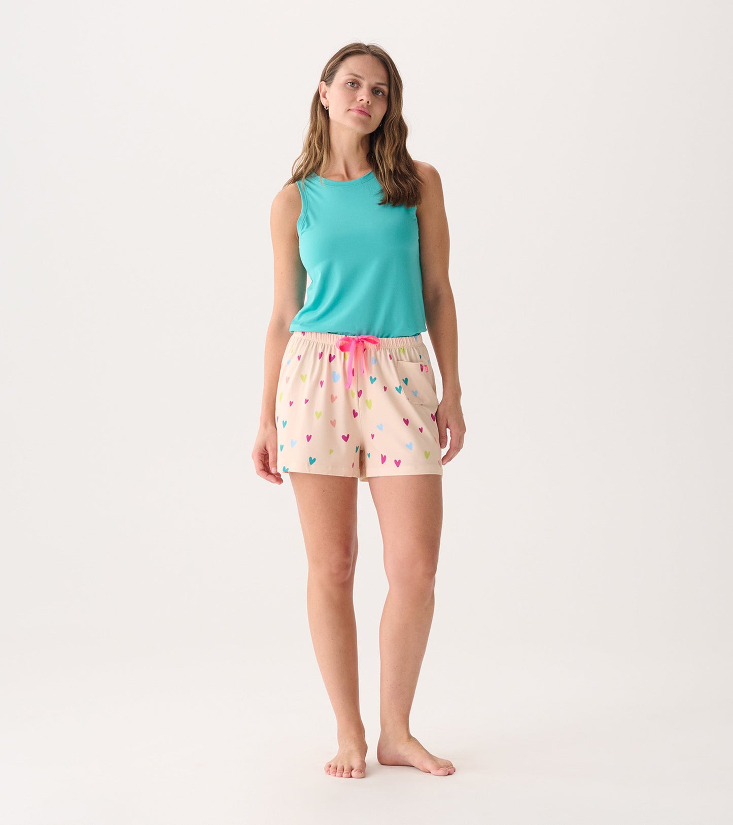 Turquoise scoop neck tank top paired with light pink shorts featuring colorful heart patterns.