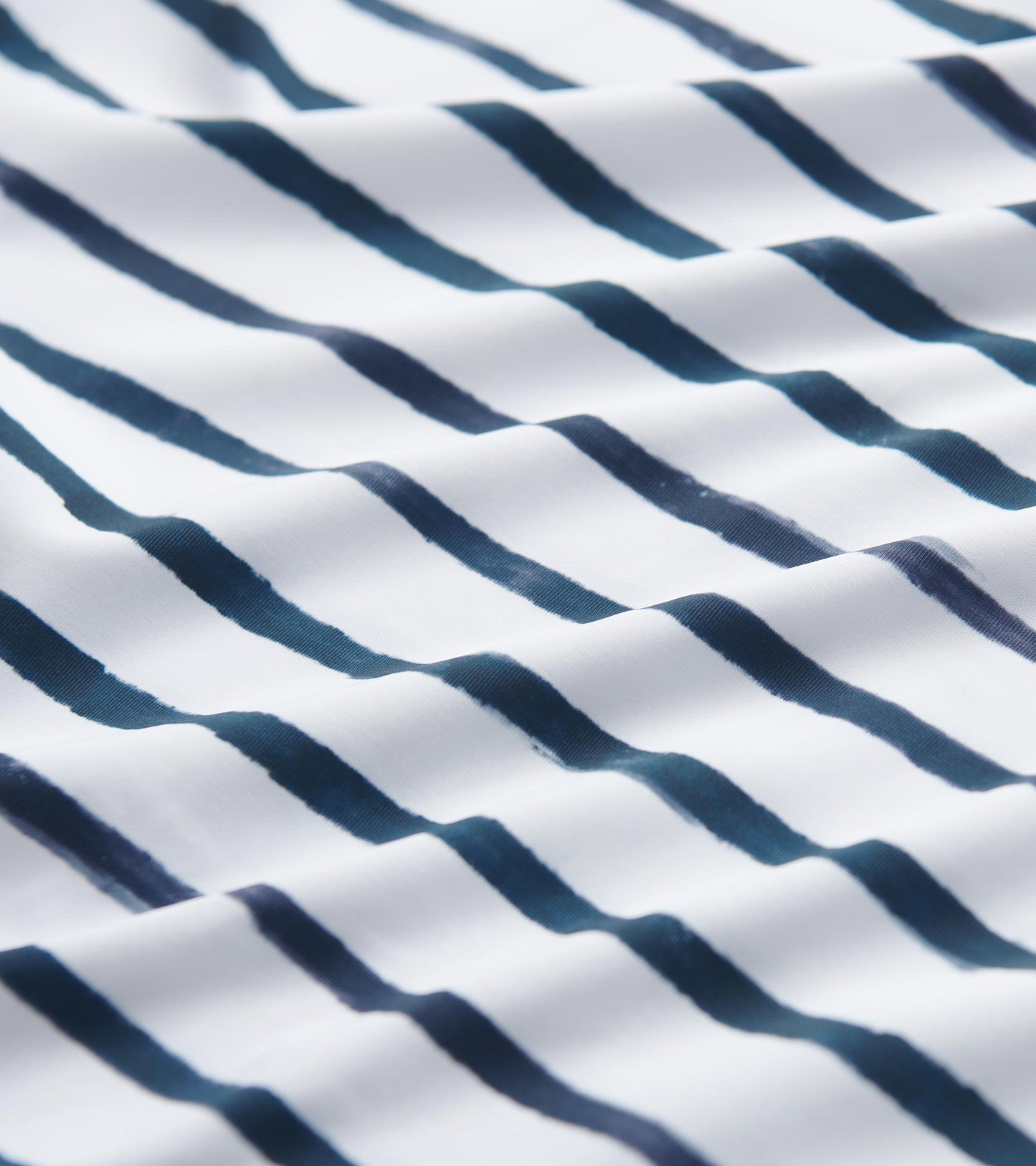 White fabric featuring watercolor stripes in navy blue, designed for a 3/4 sleeve summer dress.