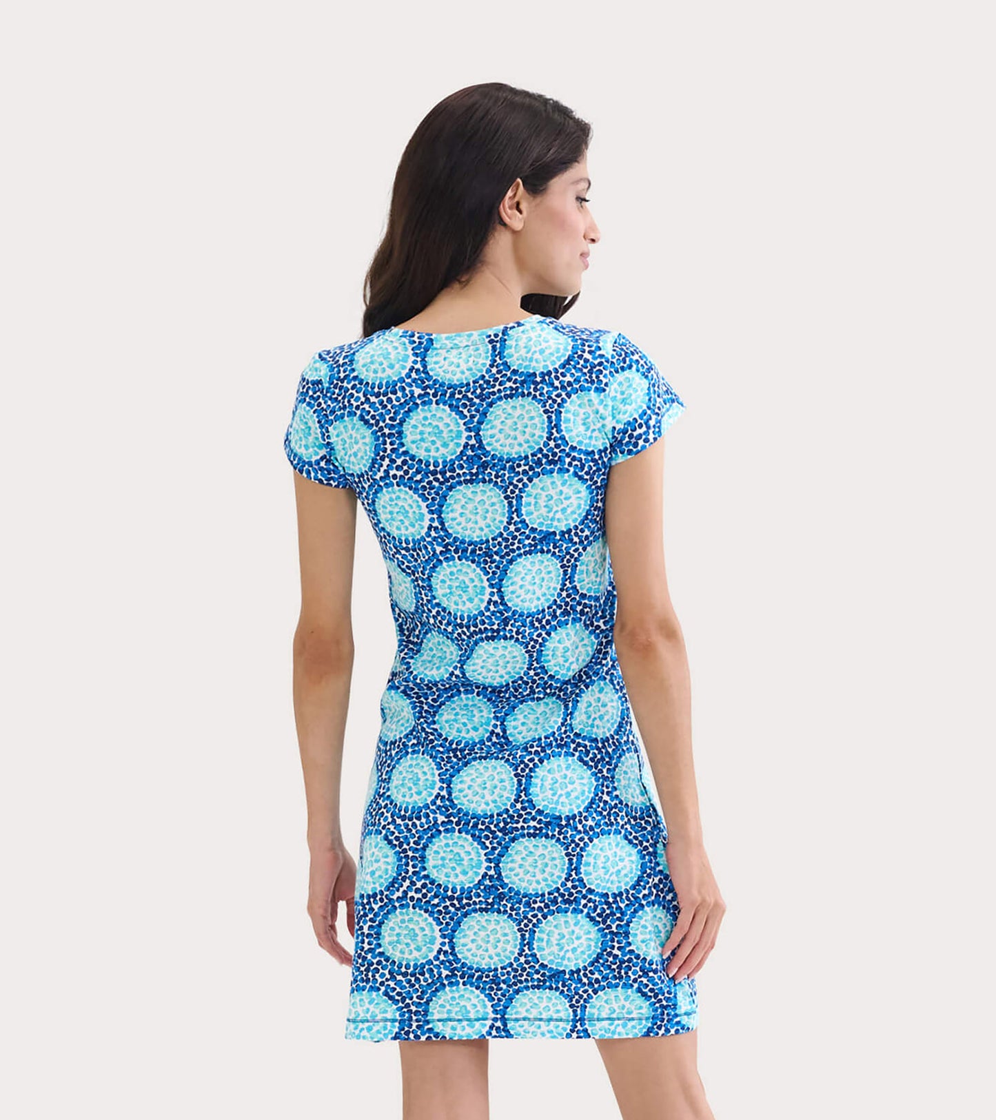 Short-sleeve crew neck dress featuring a blue and turquoise circular pattern, shown from the back.