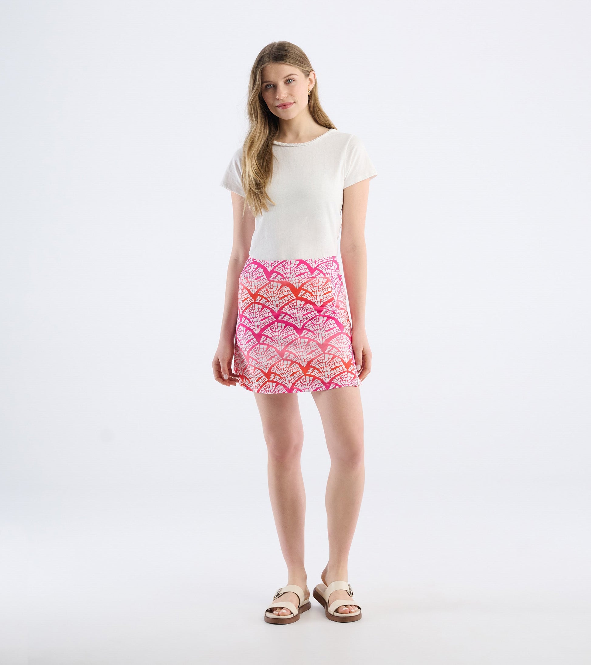 Colorful skort featuring a vibrant pink and orange fan pattern, paired with a simple white top and sandals.