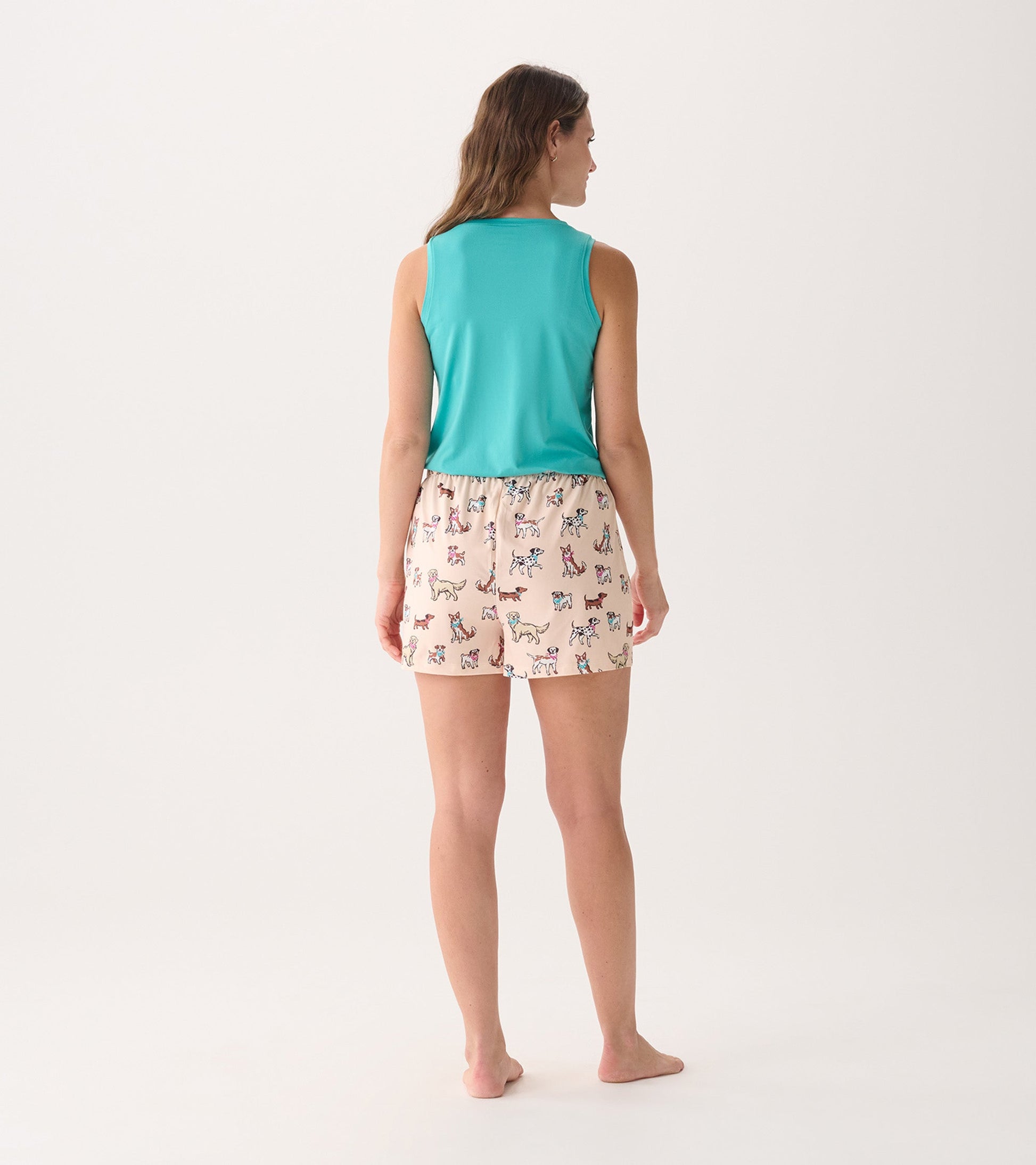 Back view of women's pajama set featuring a teal tank top and light pink shorts with colorful dog prints.
