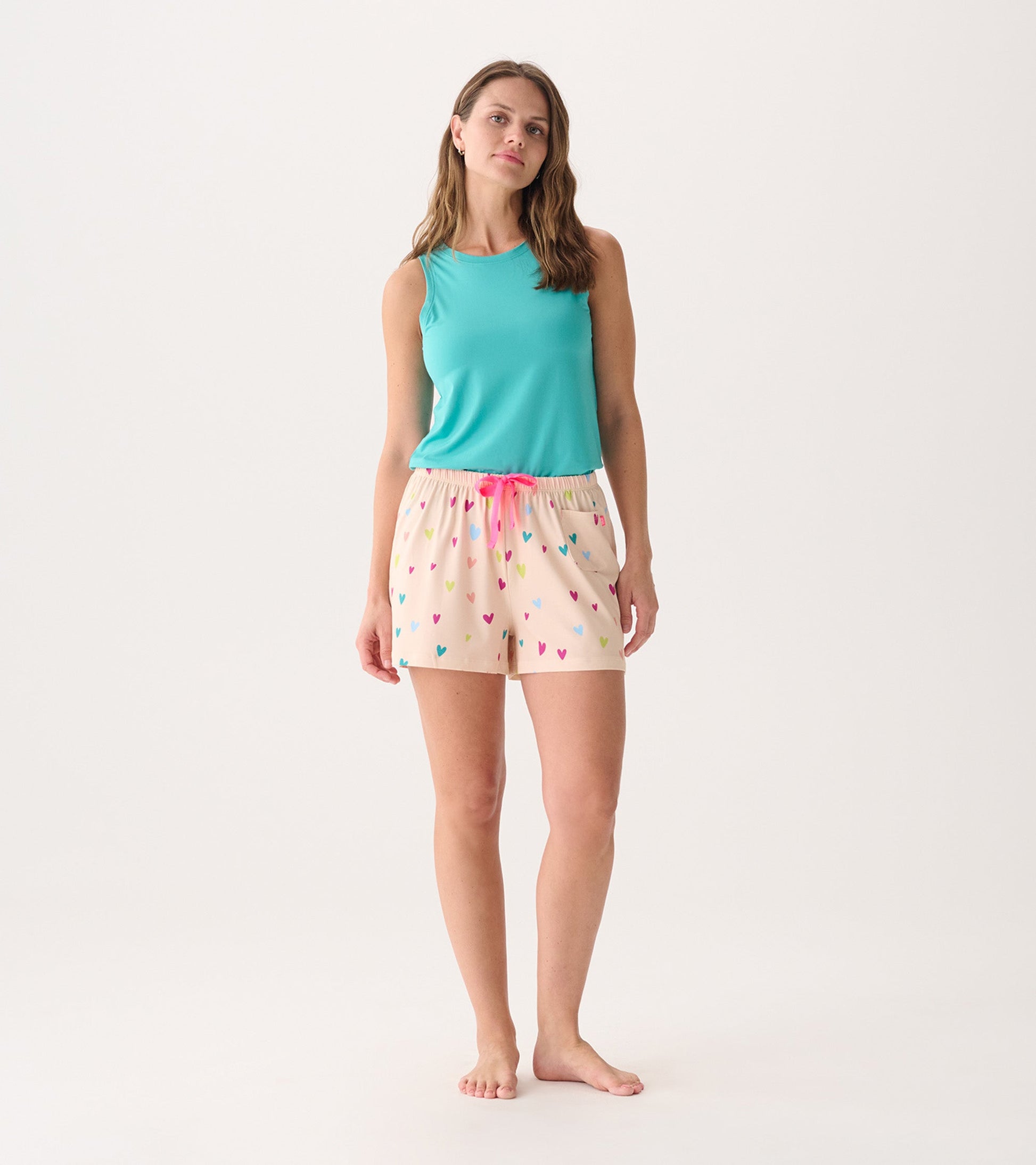 Light blue sleeveless top paired with pink heart-patterned shorts featuring an elastic waistband and drawstring.