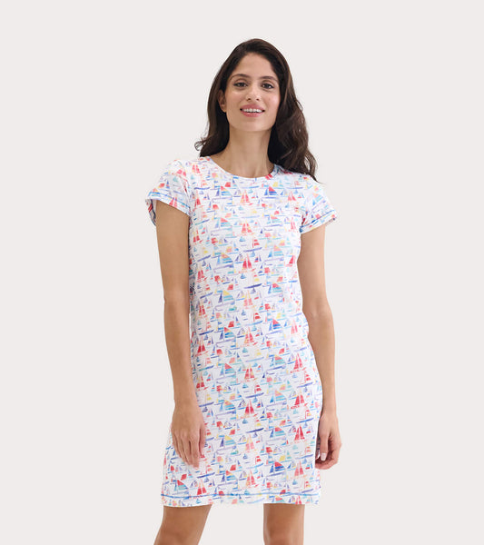 White crew neck t-shirt dress featuring a colorful sailboat print, short sleeves, and a relaxed fit.
