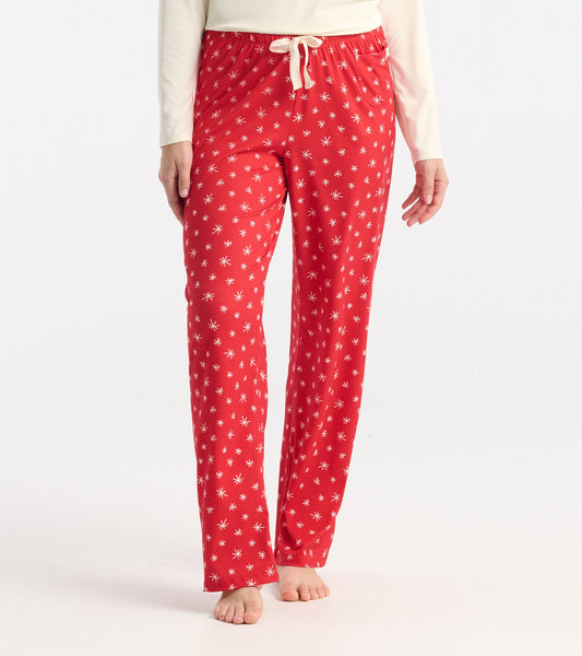 Red polyknit pajama pants featuring a white snowflake pattern, with an elastic waistband and drawstring.