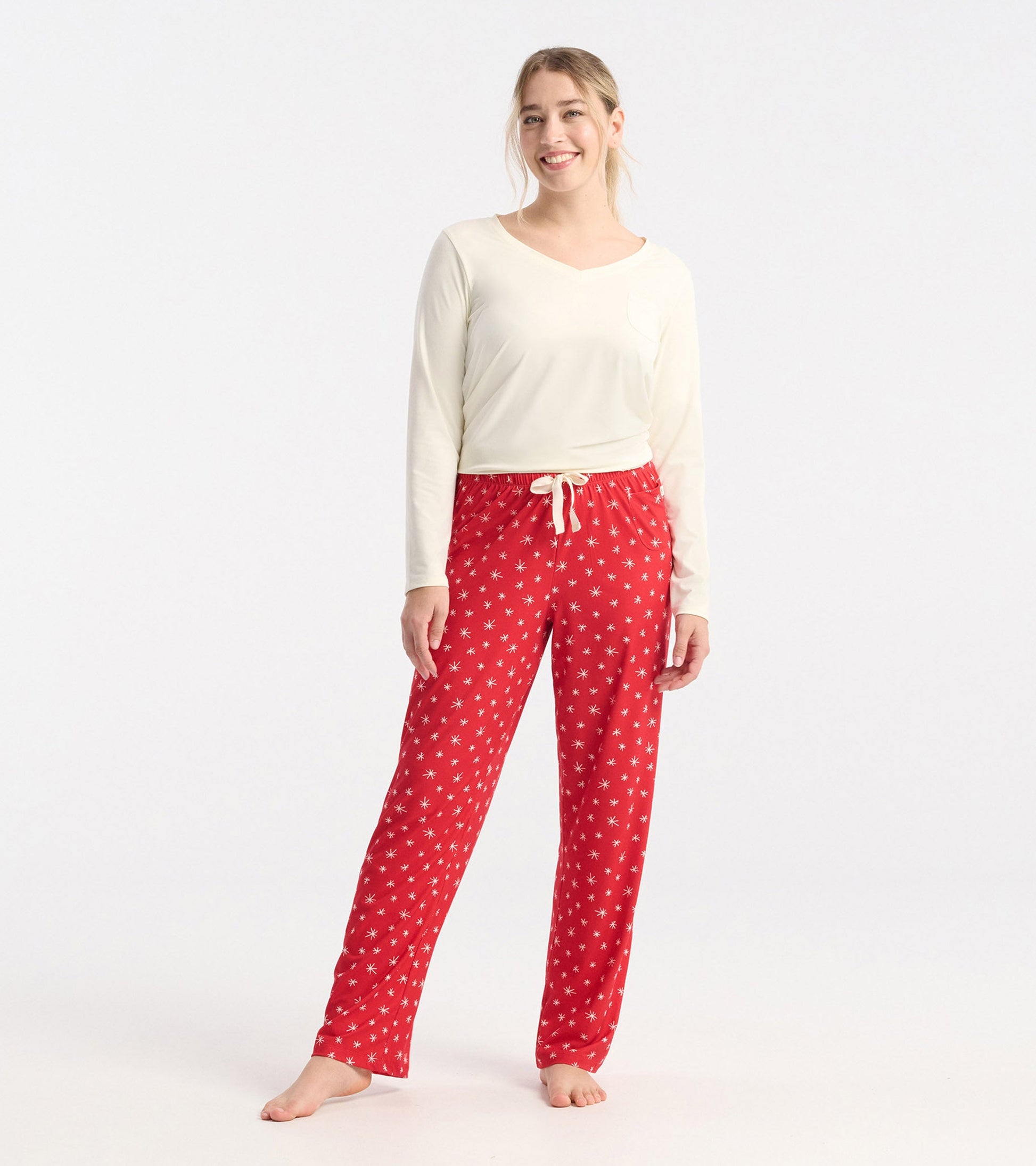 Red polyknit pajama pants featuring a snowflake pattern and an elastic waistband with a drawstring.