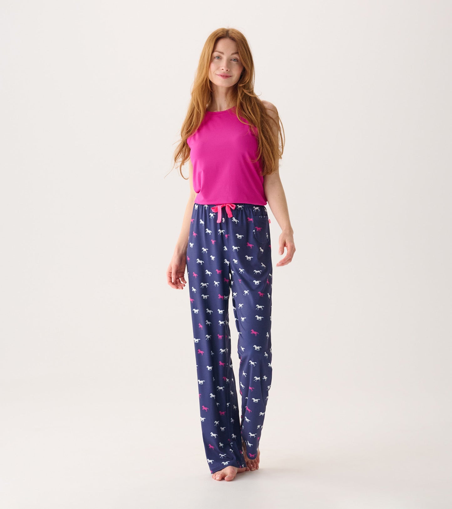 Fuchsia scoop neck tank top paired with navy pants featuring a playful horse print.