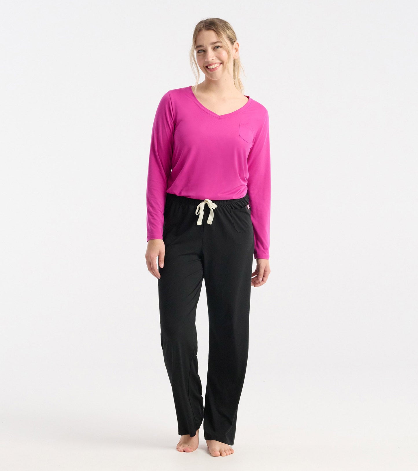 Long sleeve t-shirt in rose violet polyknit with a v-neck and pocket, paired with black pants.