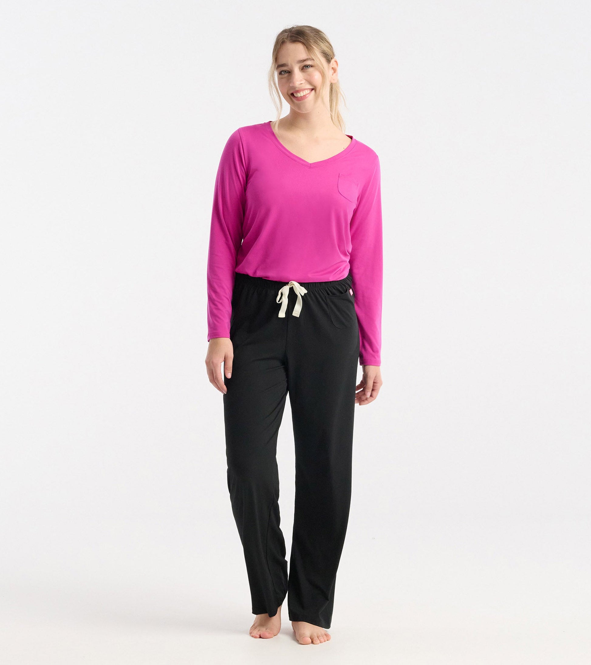 Long sleeve t-shirt in rose violet polyknit with a v-neck and pocket, paired with black pants.
