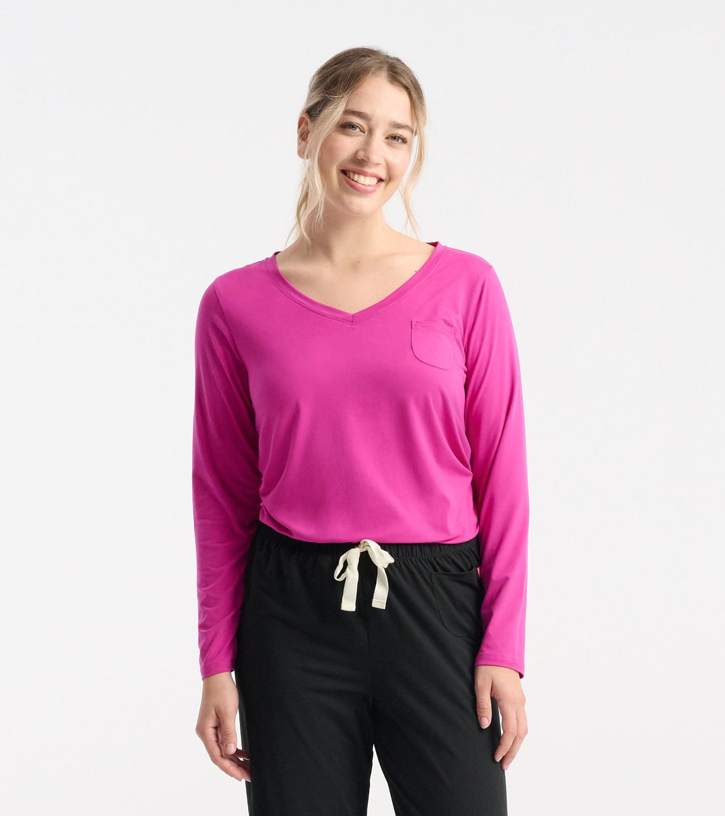 Long sleeve T-shirt in vibrant rose violet with a V-neck and a chest pocket, styled with black pants.
