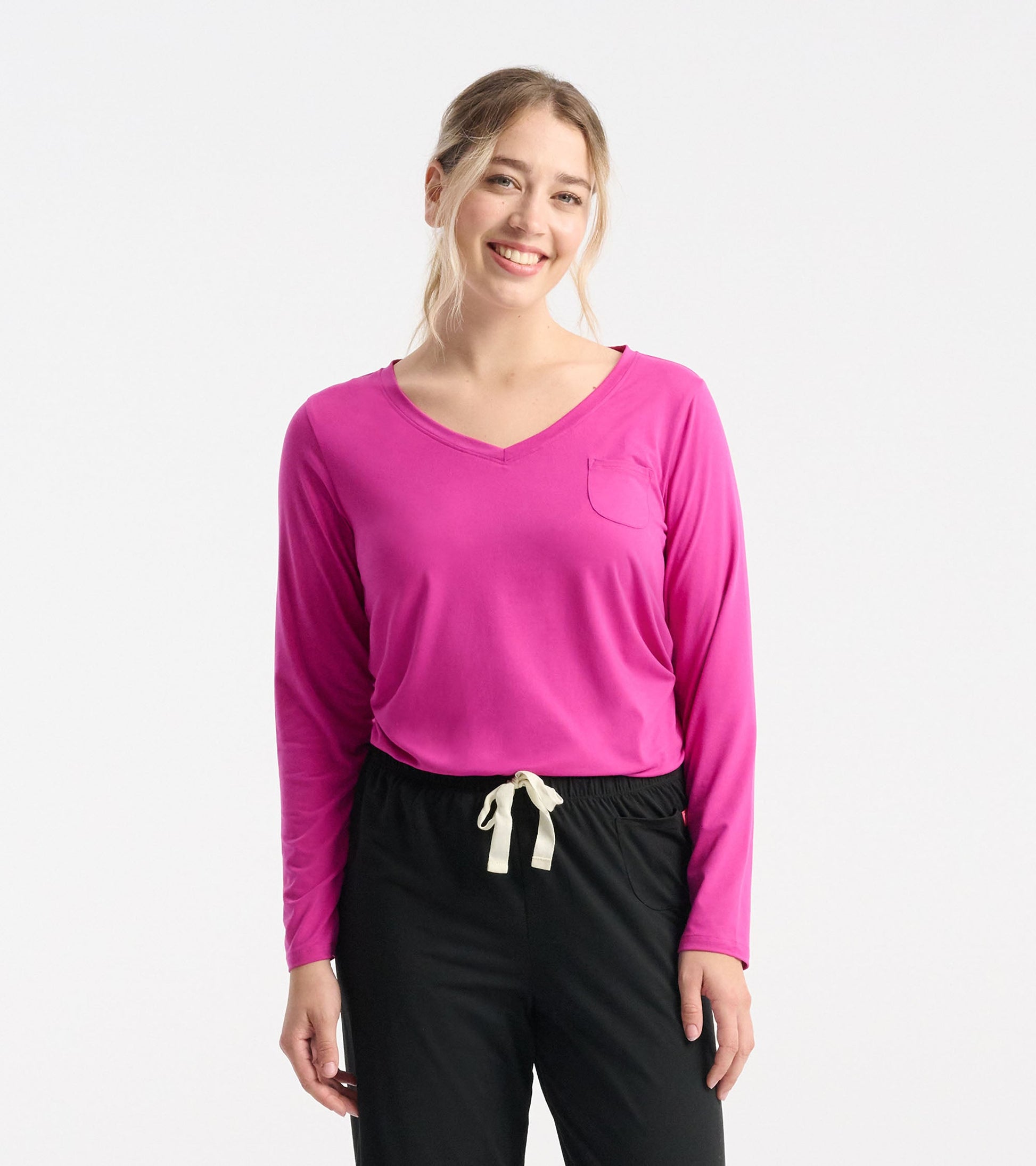 Long sleeve T-shirt in vibrant rose violet with a V-neck and a chest pocket, styled with black pants.
