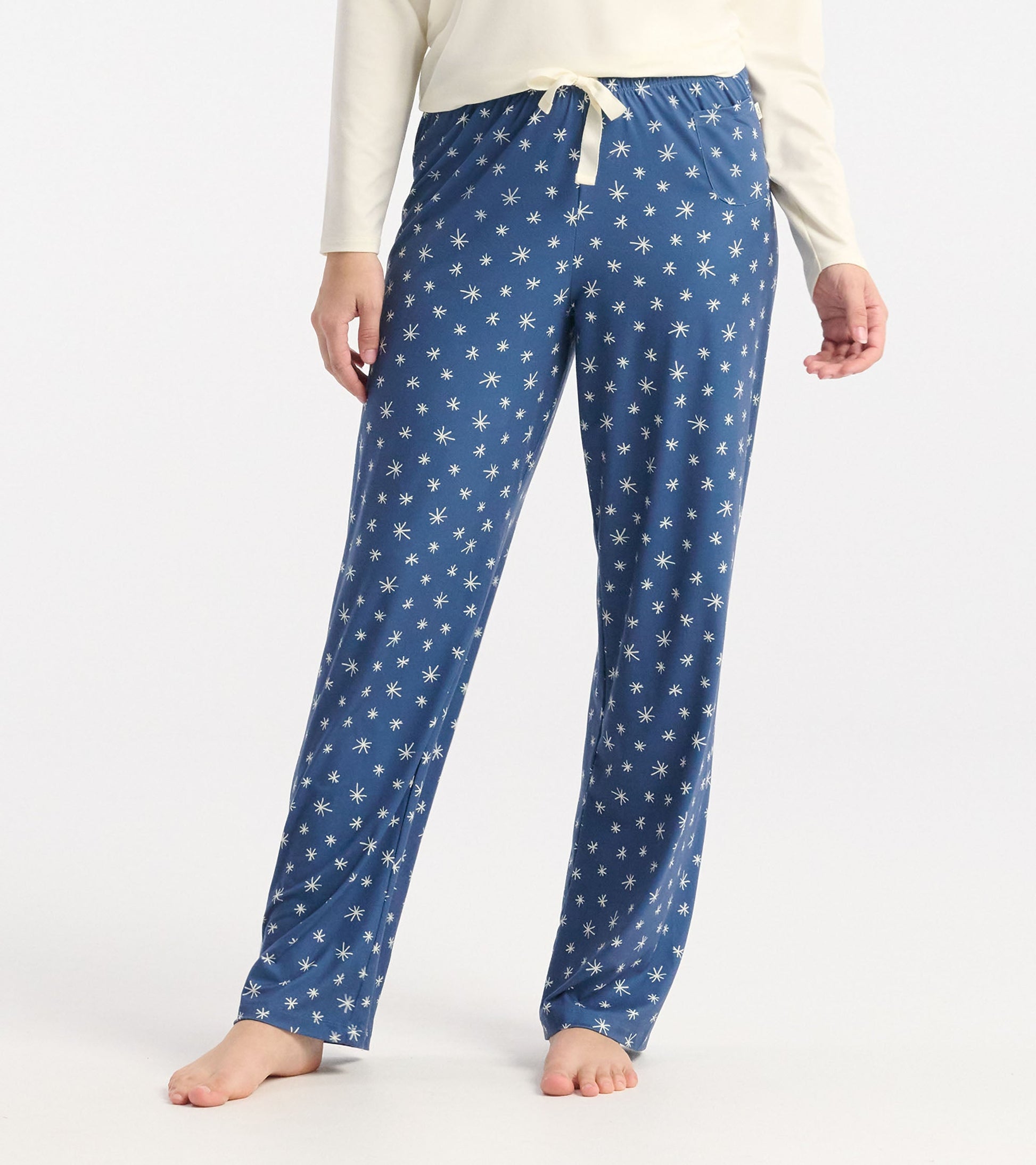 Blue polyknit pajama pants featuring a snowflake pattern, with an elastic waistband and drawstring detail.