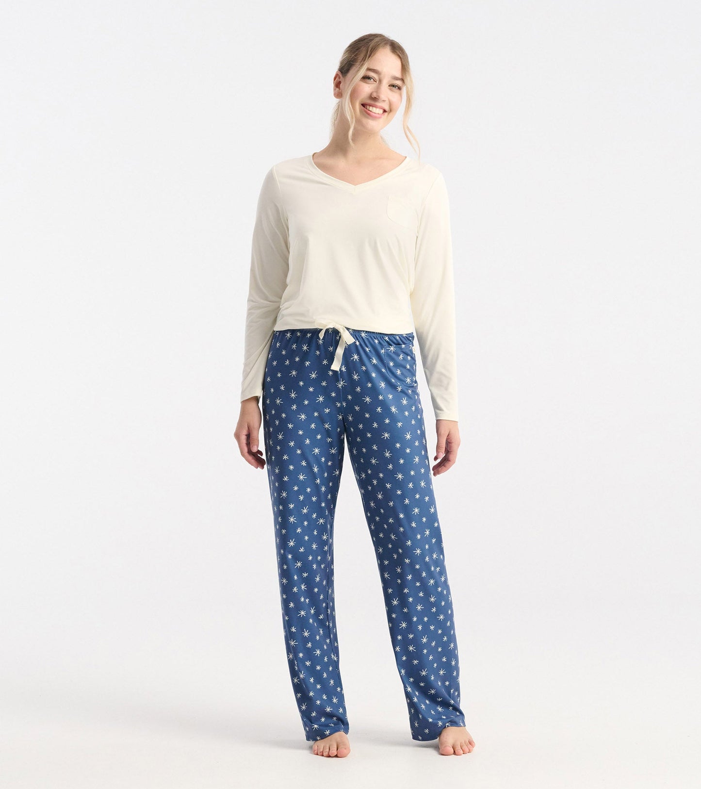 Blue polyknit pajama pants with white snowflake pattern, featuring an elastic waistband and relaxed fit.