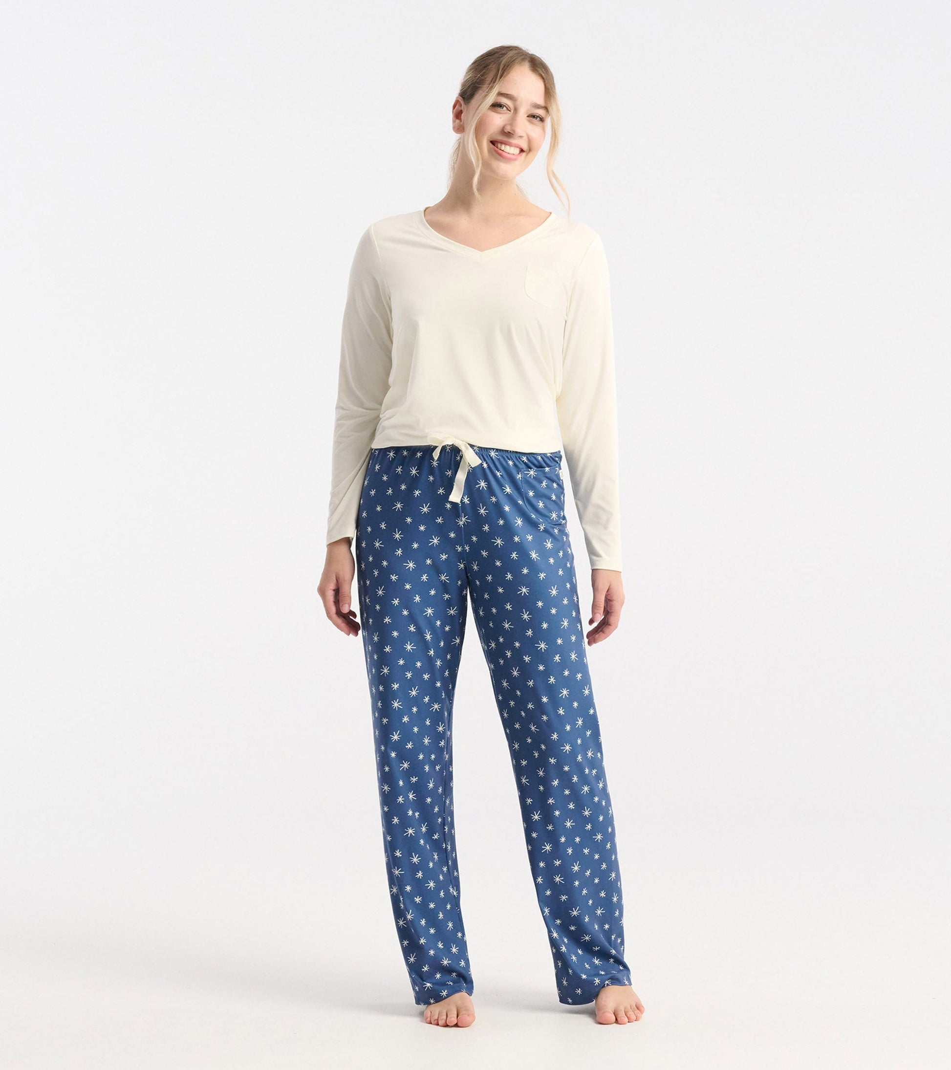 Blue polyknit pajama pants with white snowflake pattern, featuring an elastic waistband and relaxed fit.