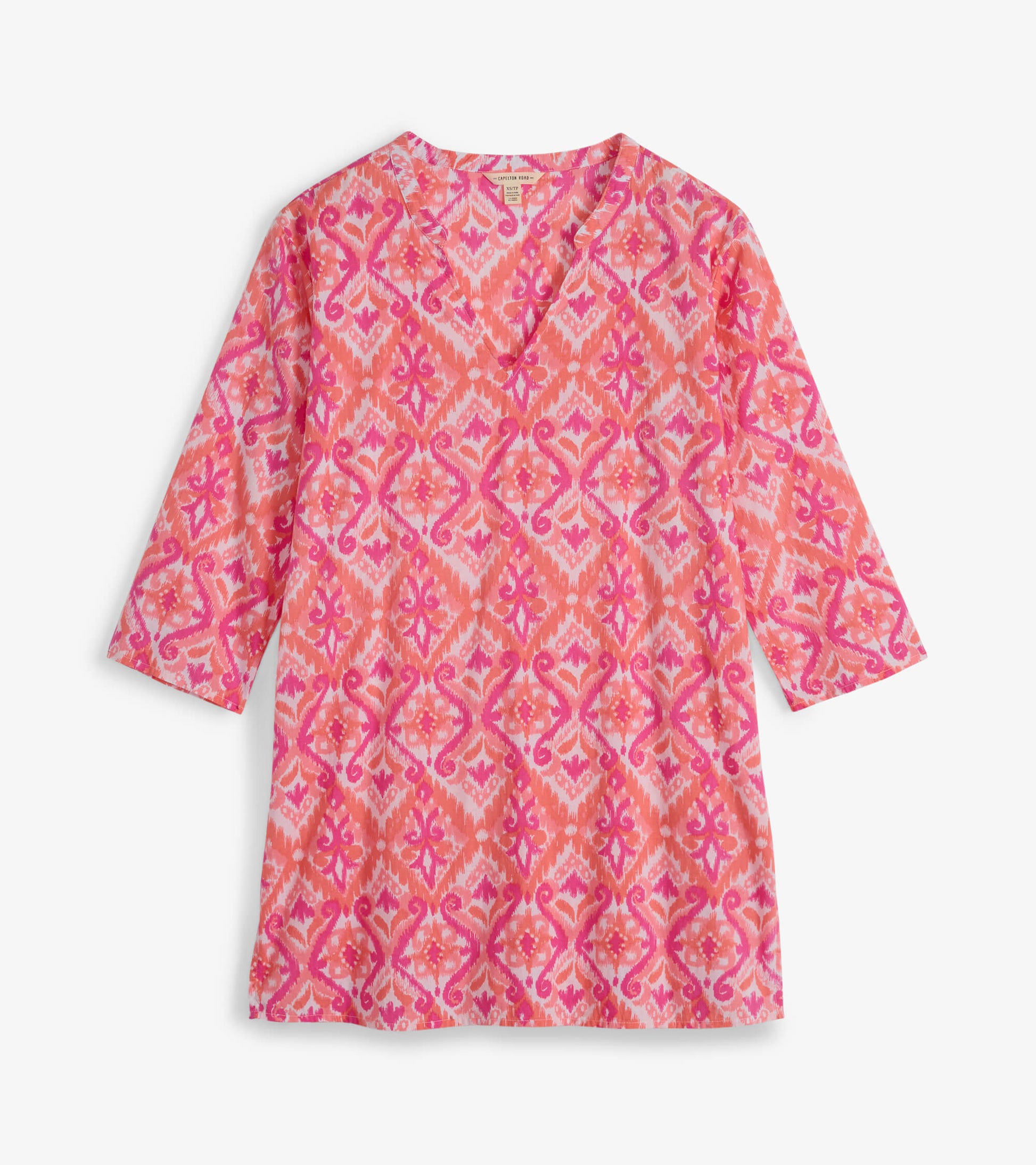 Pink and coral tunic with a vibrant ikat pattern and three-quarter sleeves, featuring a V-neckline.