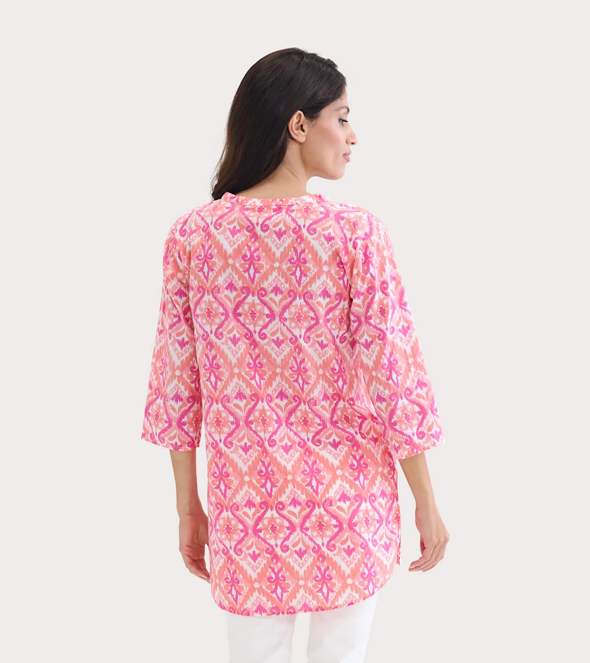 Pink and orange ikat patterned tunic with three-quarter sleeves, shown from the back.