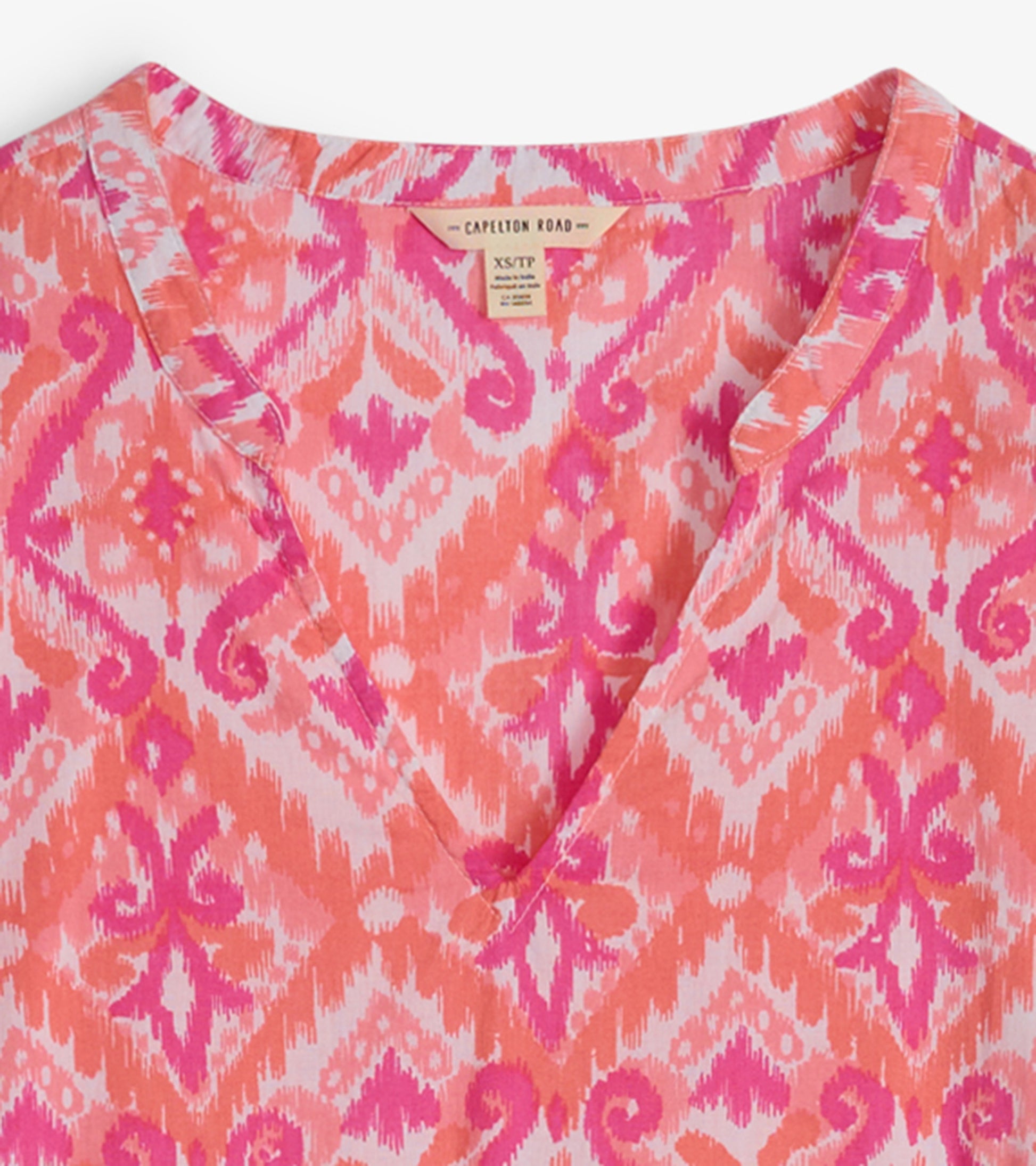 Pink and orange ikat patterned tunic with a V-neckline, lightweight fabric, suitable for casual wear.