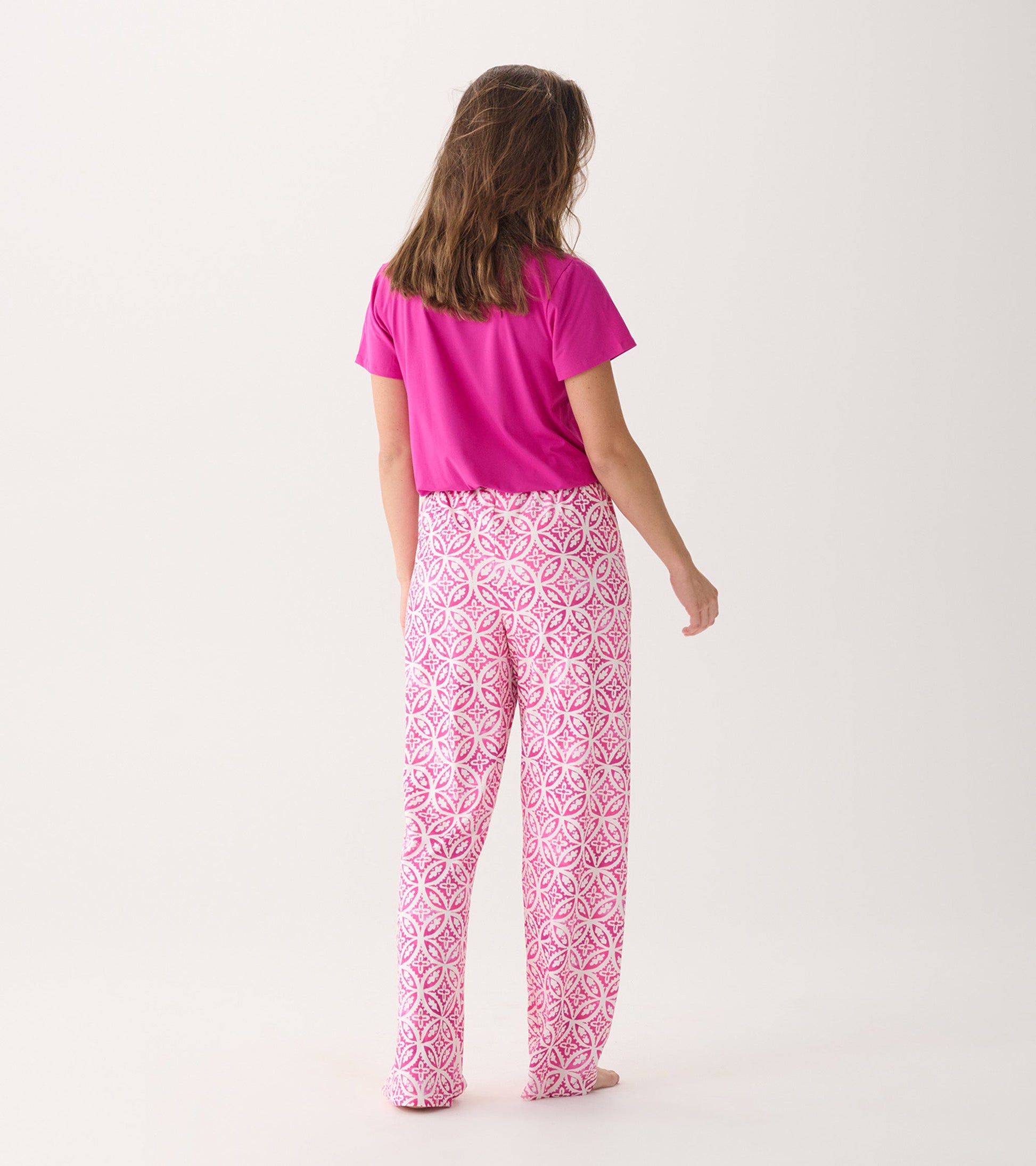 Pink pajama pants featuring a lotus mandala pattern, made from soft polyknit fabric, shown from the back.
