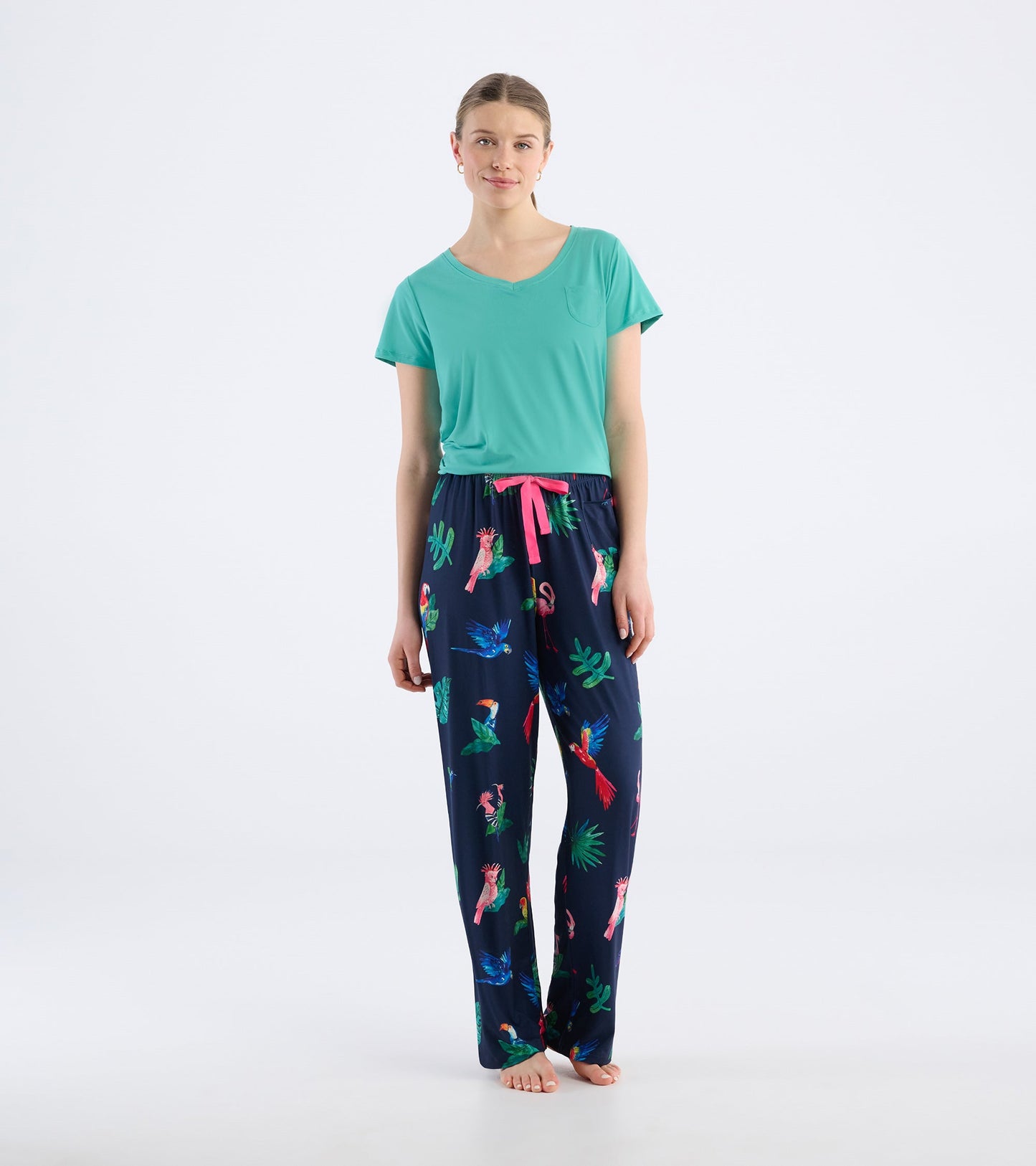 Navy pajama pants featuring a tropical bird print and a pink drawstring, paired with a teal top.