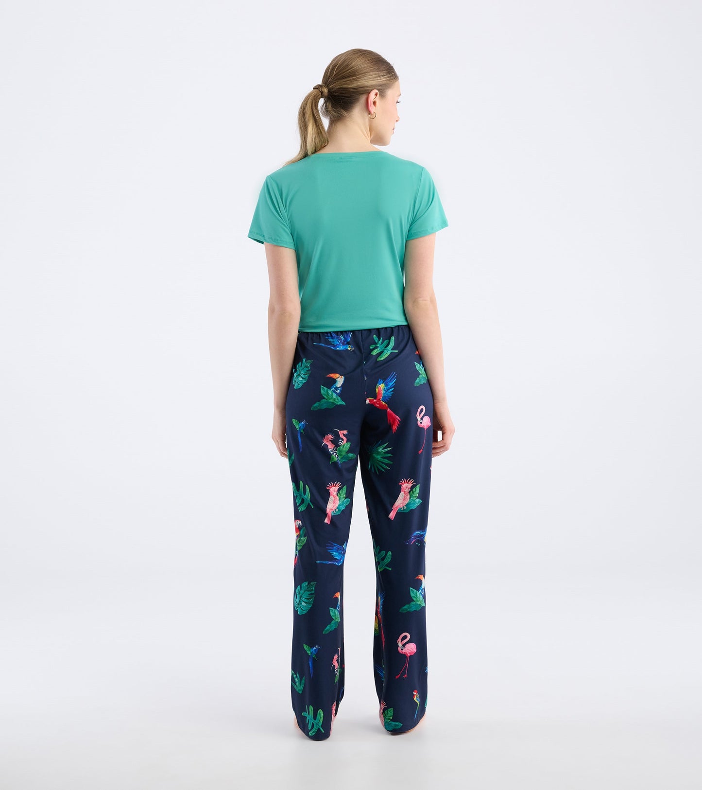 Navy pajama pants featuring a colorful tropical bird and leaf pattern, made from soft polyknit fabric.