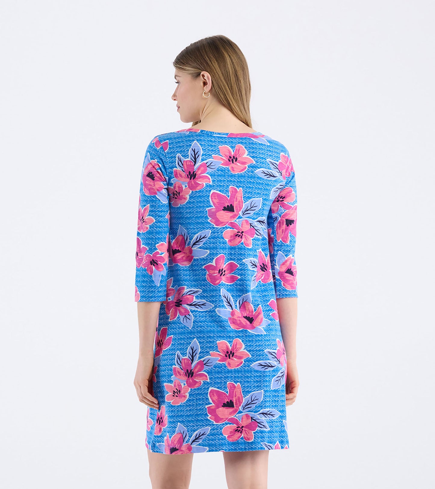 Bateau dress featuring a vibrant blue background with bold pink floral patterns and three-quarter sleeves, shown from the ba…