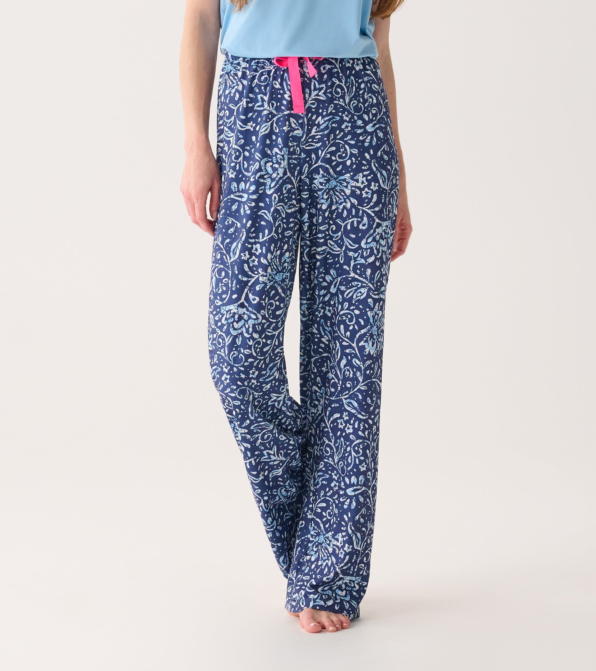 Navy blue pajama pants with a floral batik pattern and a pink drawstring, designed for comfort and relaxation.