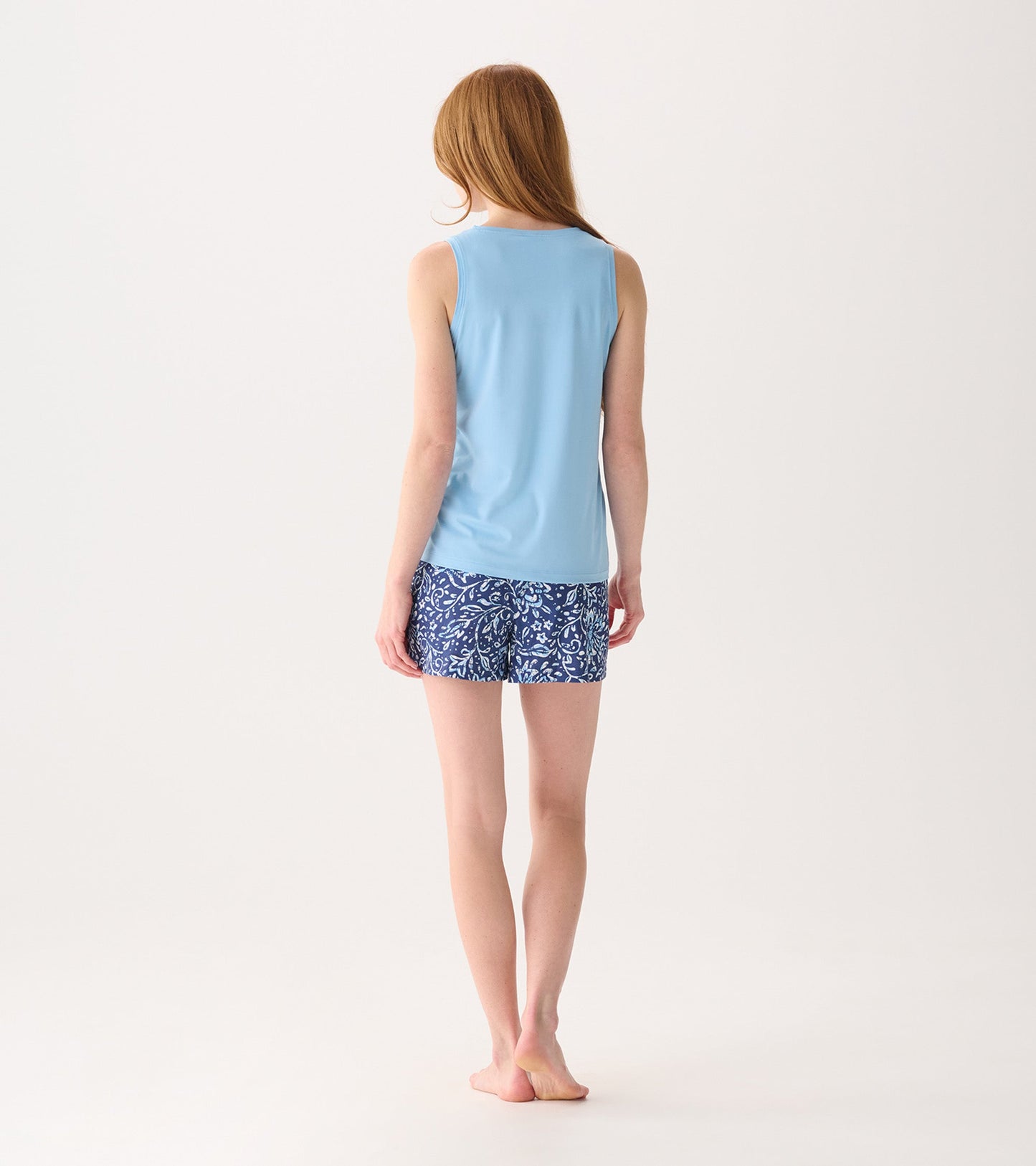 Light blue sleeveless top paired with navy shorts featuring a white floral batik pattern, viewed from the back.