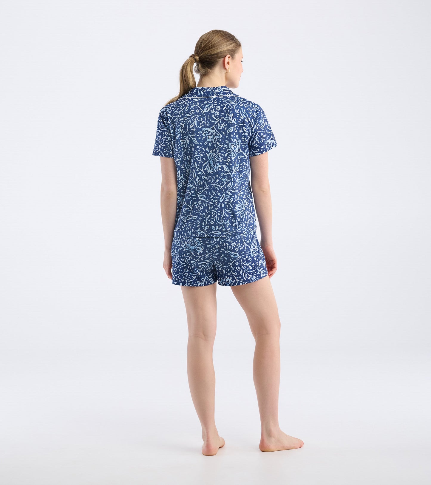 Navy blue short pajama set featuring a batik floral pattern, with a short-sleeve top and matching shorts.
