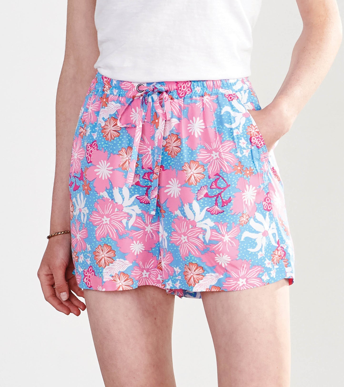 Floral print shorts in pink and blue with an elastic waistband and drawstring, featuring side pockets.