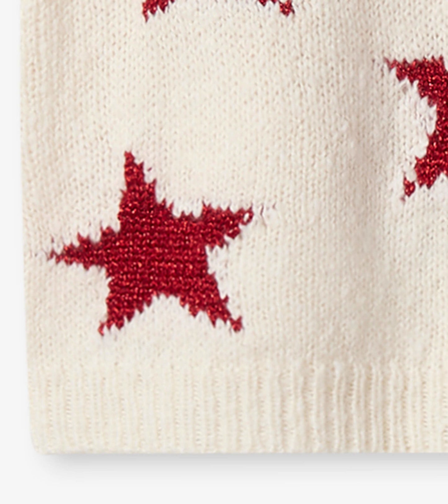 Cream sweater dress featuring red star patterns, perfect for festive occasions. Soft knit material for comfort.