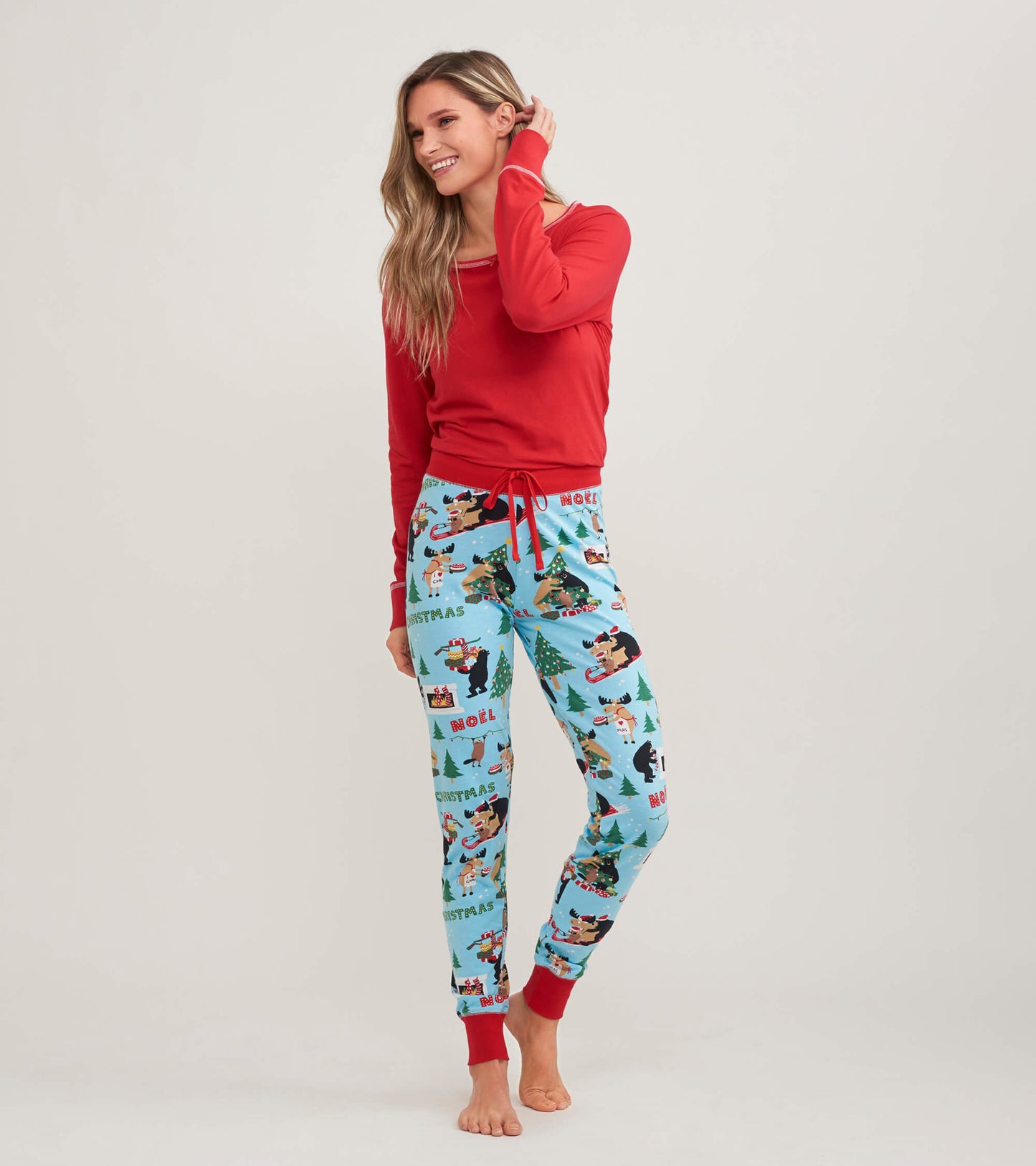 Red long sleeve pajama top paired with festive blue pajama pants featuring holiday-themed prints.
