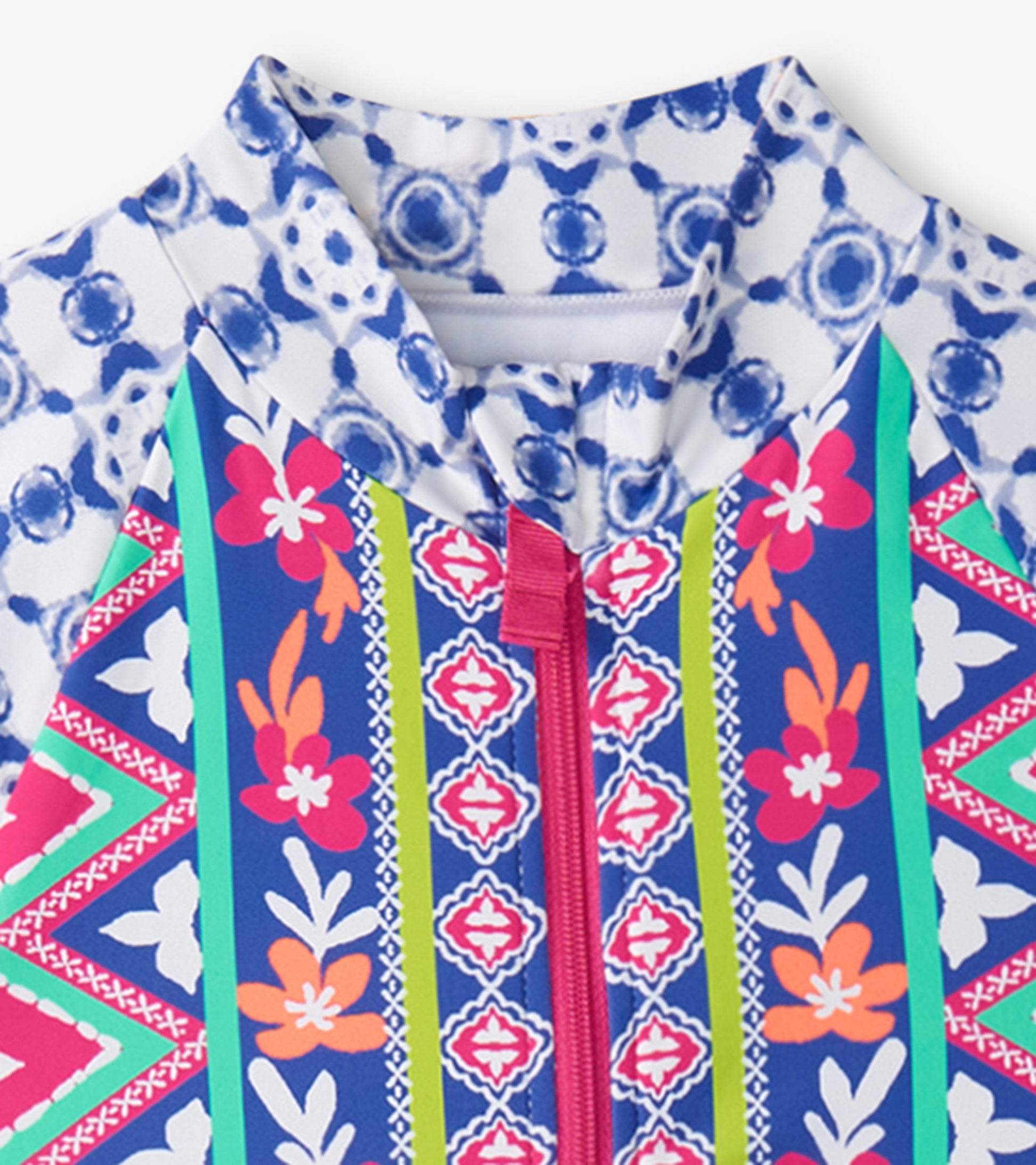 Colorful one-piece rashguard featuring floral and geometric patterns with a front zipper and high collar.