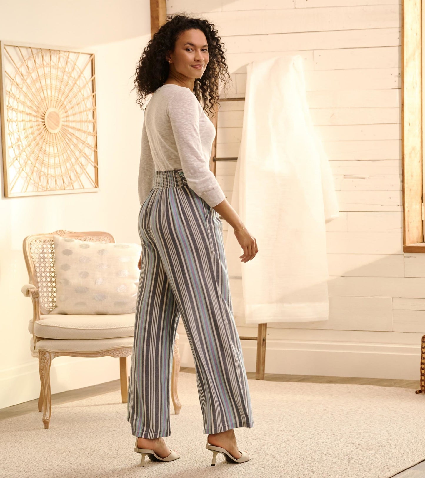 Belted wide leg pants featuring colorful rainbow stripes, shown from the back with a relaxed fit.