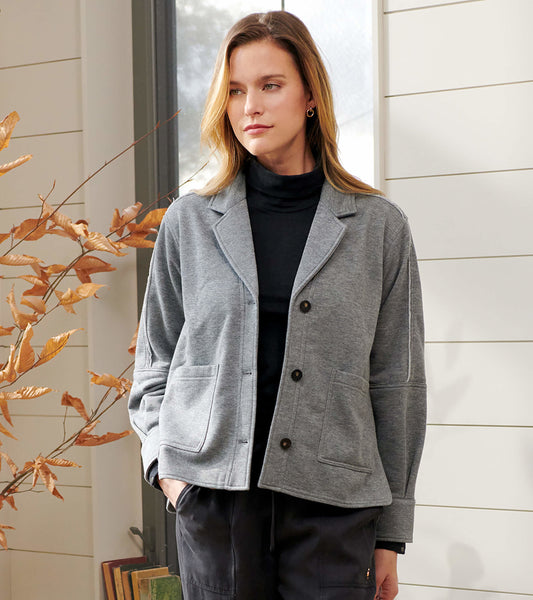 Charcoal melange relaxed blazer with a button front, two pockets, and a soft fabric, styled over a black turtleneck.