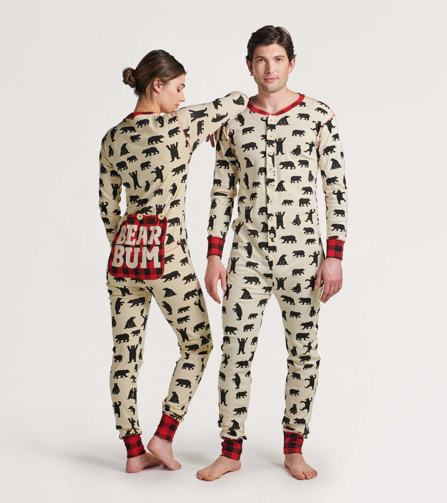 Cream onesie featuring black bear silhouettes and red plaid accents, designed for adults, shown on a male and female model.