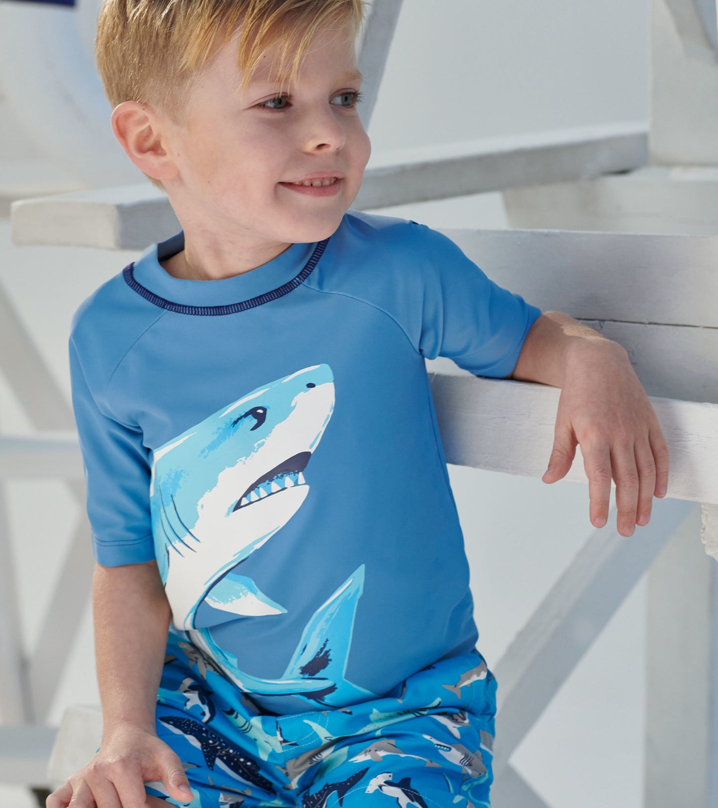 Light blue short sleeve rashguard featuring a shark graphic, perfect for beach or pool activities.