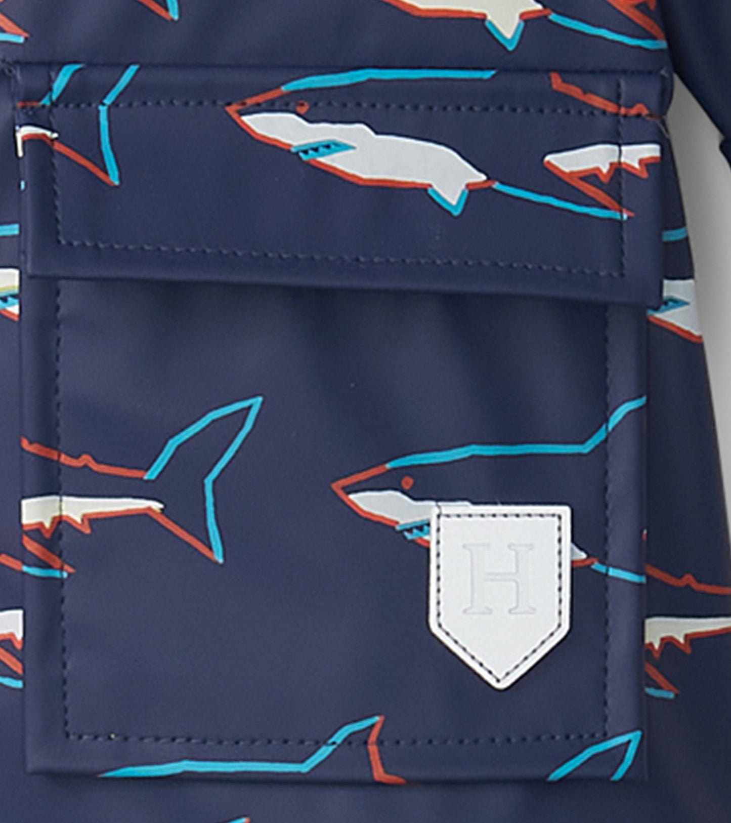 Navy rain jacket featuring colorful shark patterns and a front pocket with a logo patch. Suitable for baby and toddler boys.