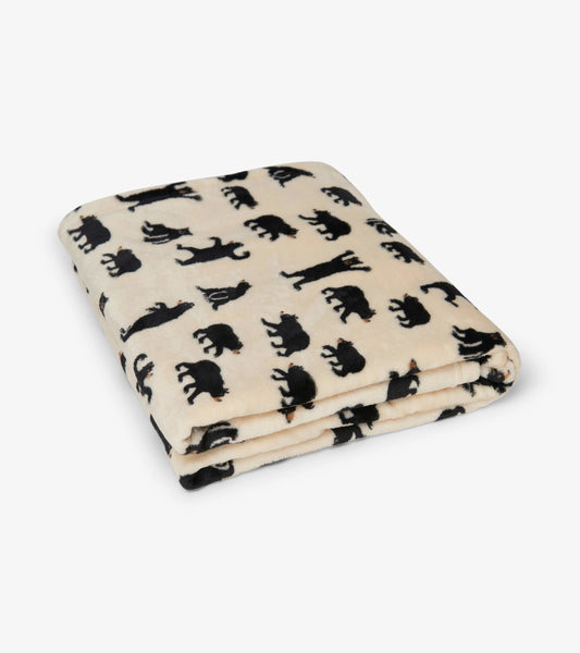 Cream fleece blanket featuring black bear silhouettes in various poses. Ideal for warmth and comfort.