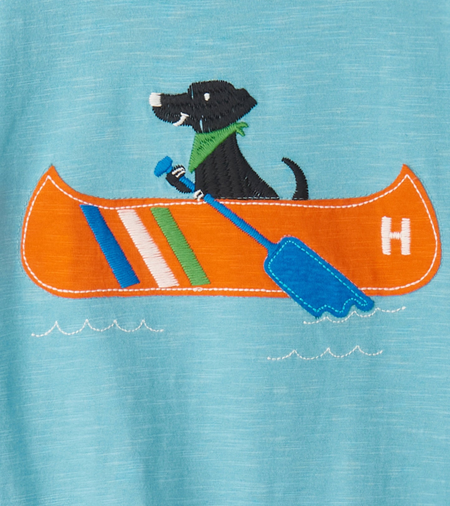 Light blue graphic tee featuring an embroidered canoe with a dog, paddle, and colorful stripes.