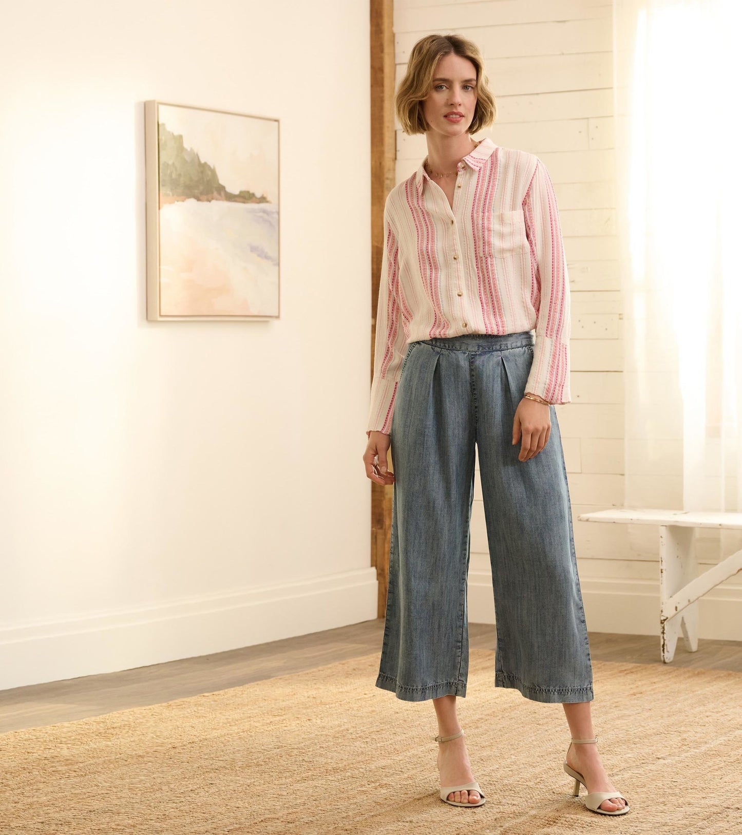 Cropped wide leg pants in blue acid rinse denim, featuring a relaxed fit and frayed hem, styled with a button-up shirt.