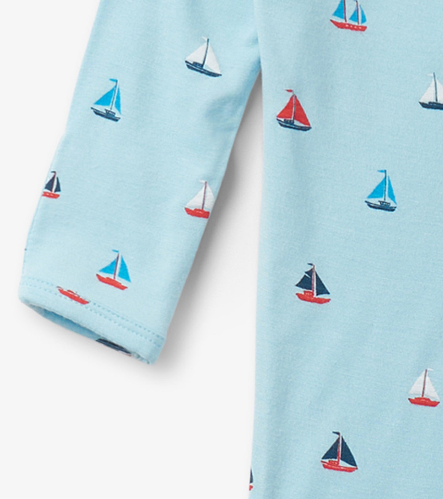 Light blue footed sleeper featuring a playful sailboat pattern in various colors. Soft fabric ideal for baby comfort.