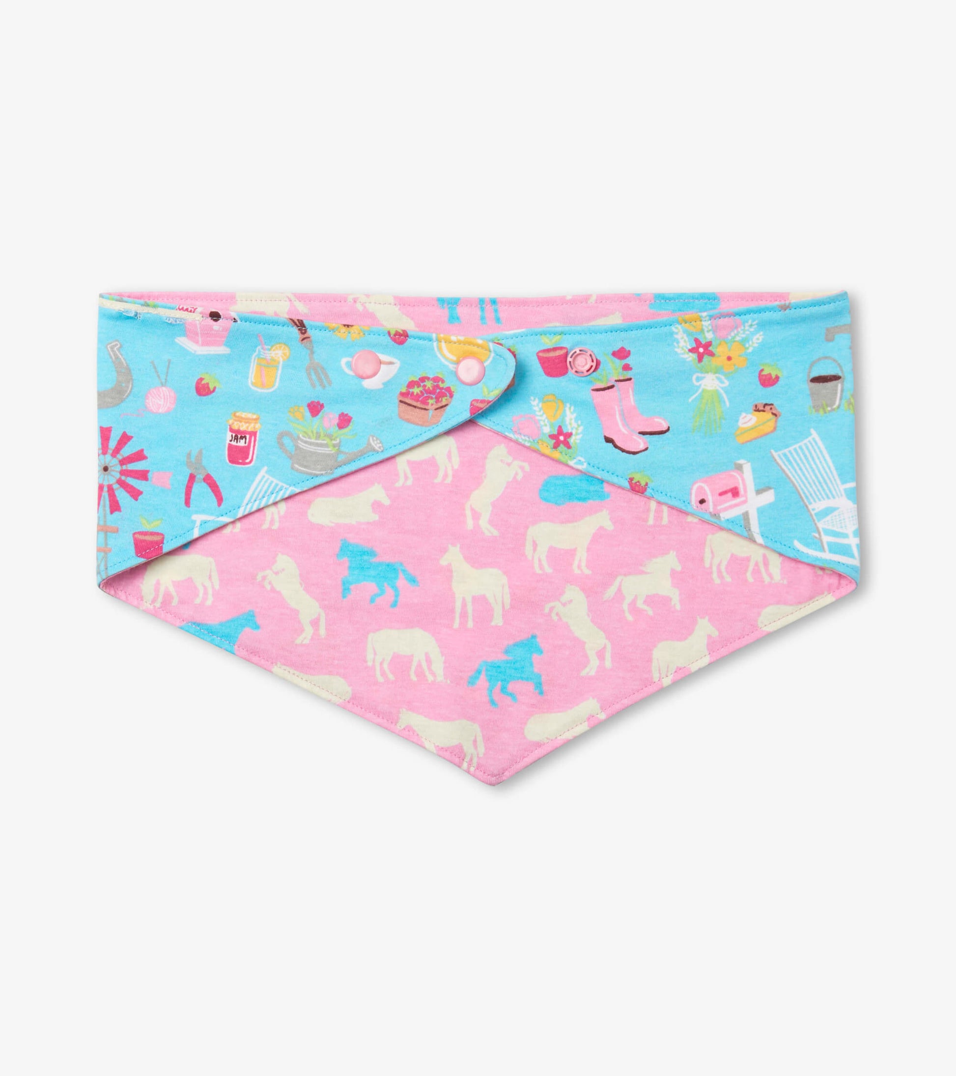 Reversible dog bandana featuring a blue side with colorful farm-themed prints and a pink side with horse silhouettes.