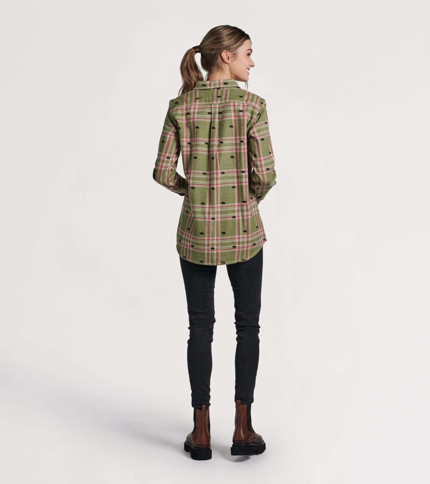 Green flannel shirt with a plaid pattern and bear motifs, shown from the back, paired with black skinny jeans.