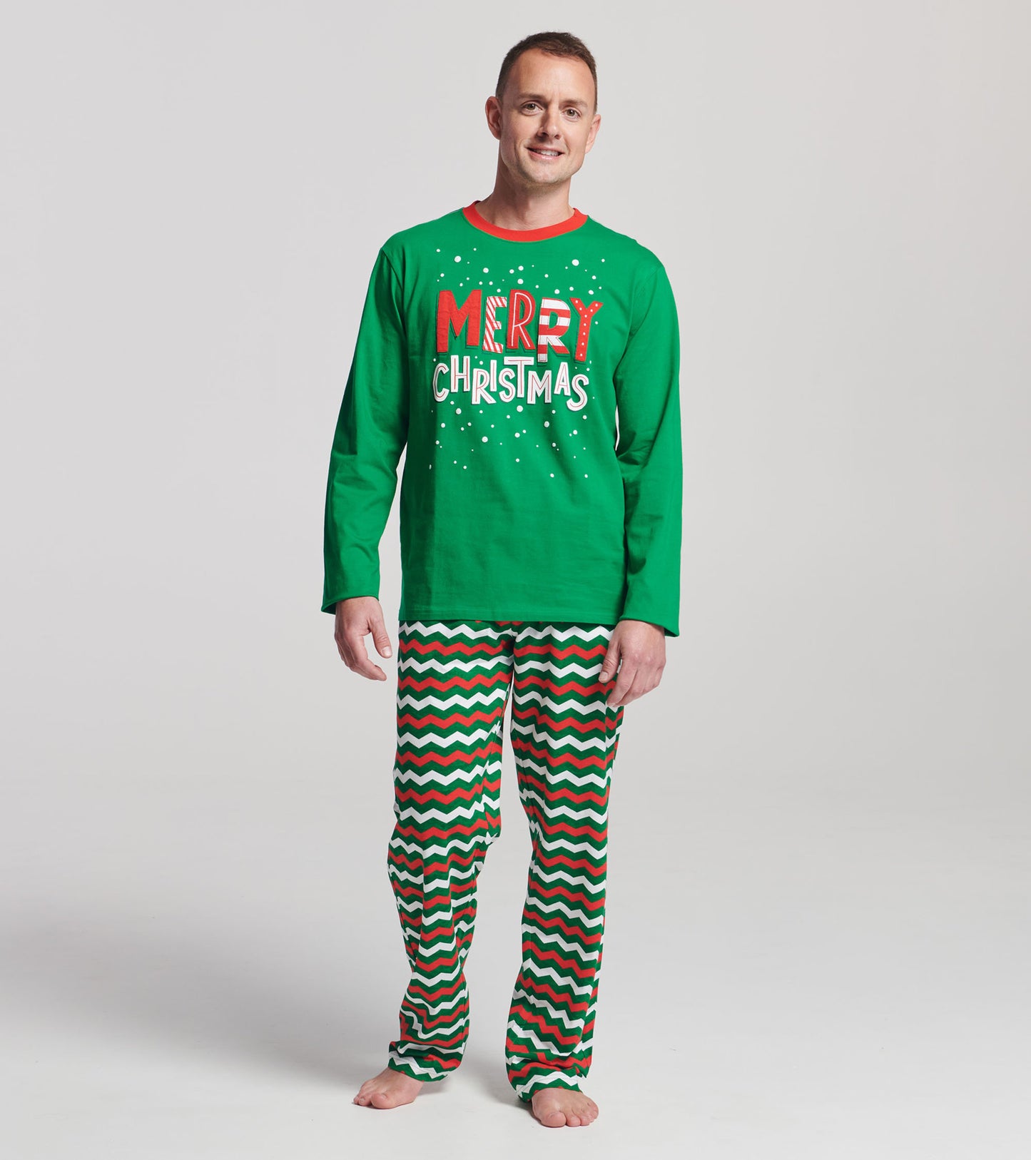 Green long-sleeve shirt with "Merry Christmas" text paired with red, white, and green zig-zag patterned pajama pants.