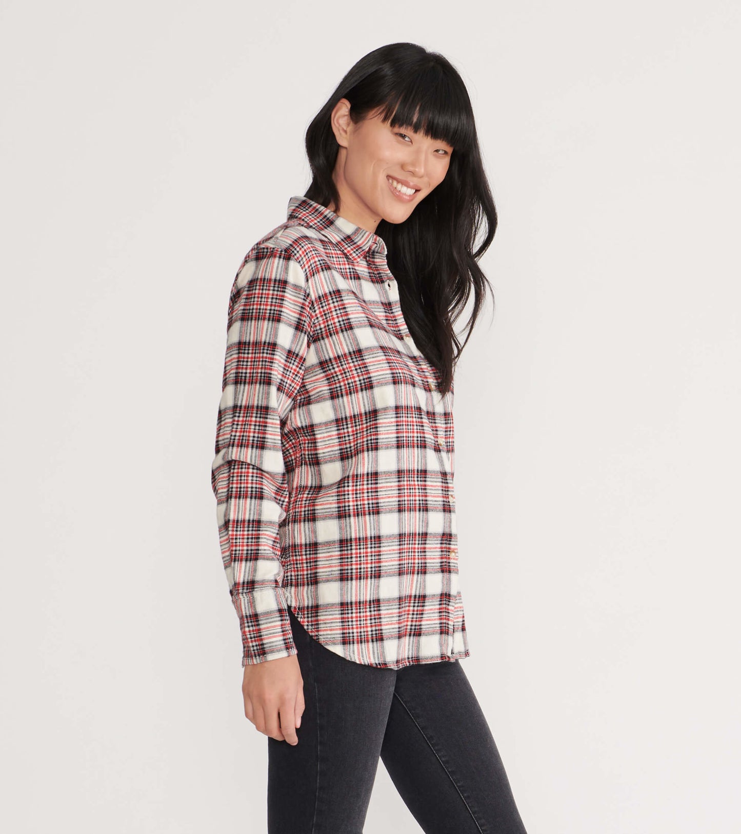 Cream plaid flannel shirt with red and black accents, featuring a button-up front and long sleeves, worn casually.